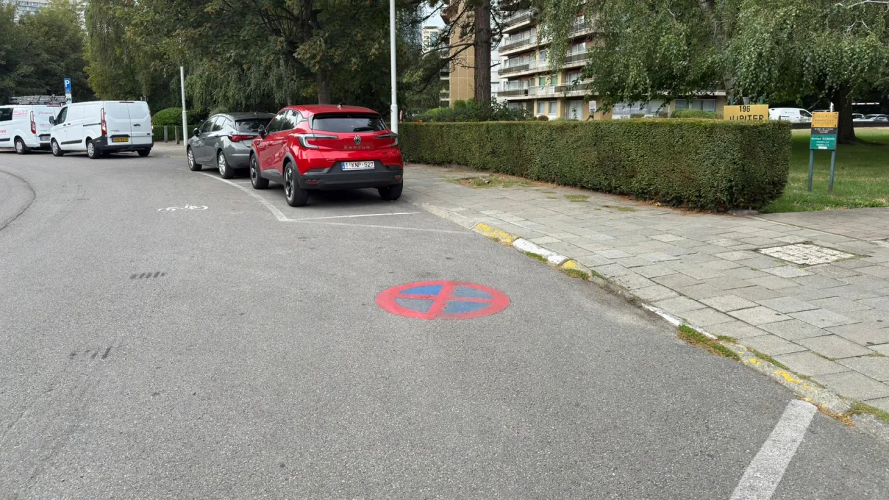 Disque bleu à deux barres rouges croisées, peint directement sur la chaussée