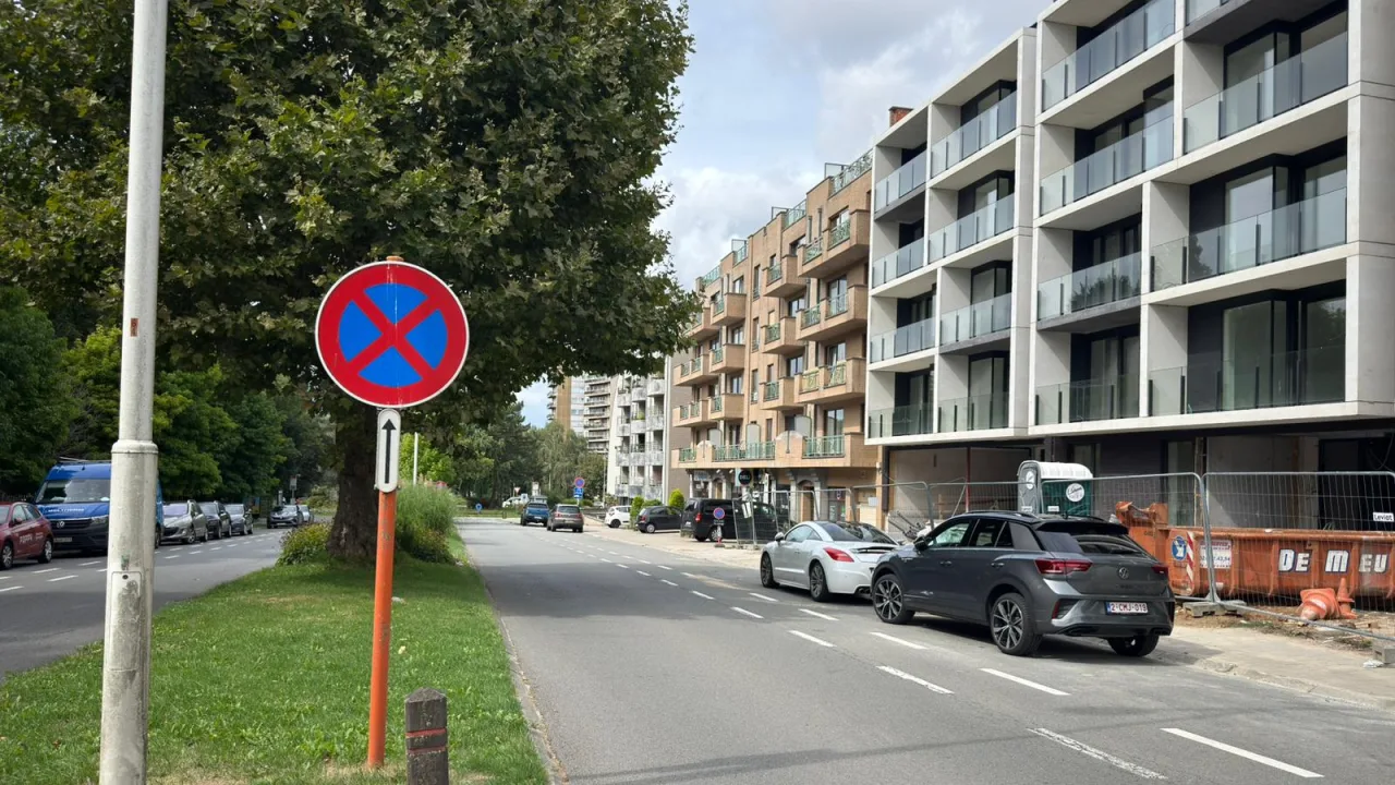 Signal rond bleu barré de deux obliques rouges croisées, au bord d'une chaussée