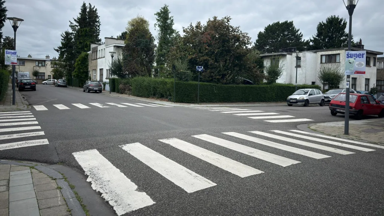 Carrefour de quatre voies en zone résidentielle, sans aucun signal ni feu, avec un passage pour piétons sur chaque branche