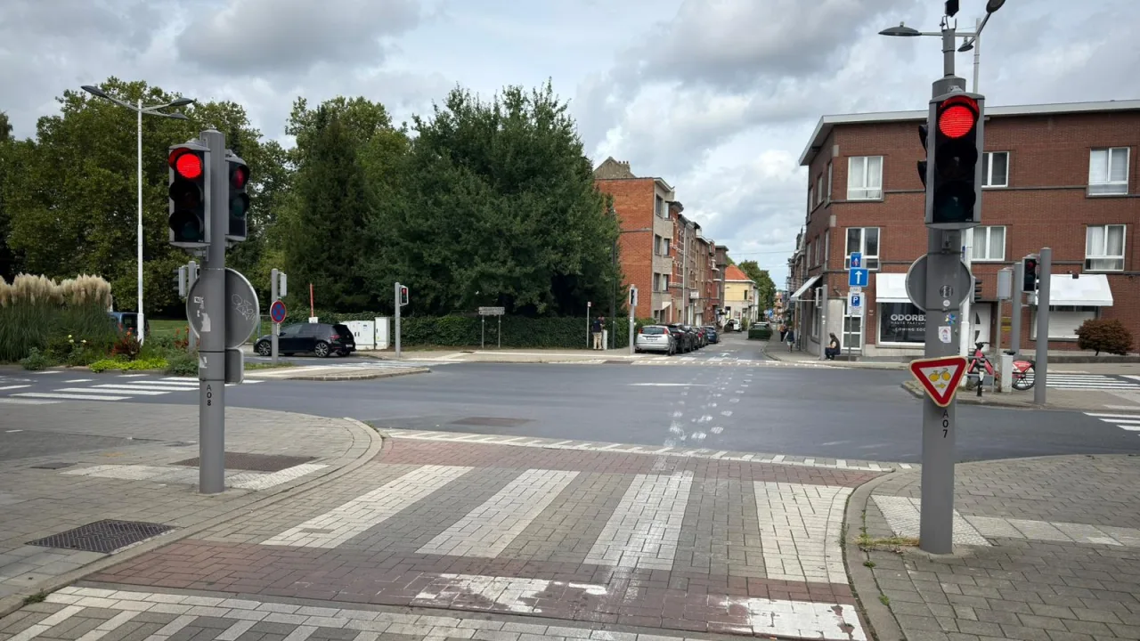 Panneau triangulaire portant un vélo et une flèche vers la droite, sous un feu rouge