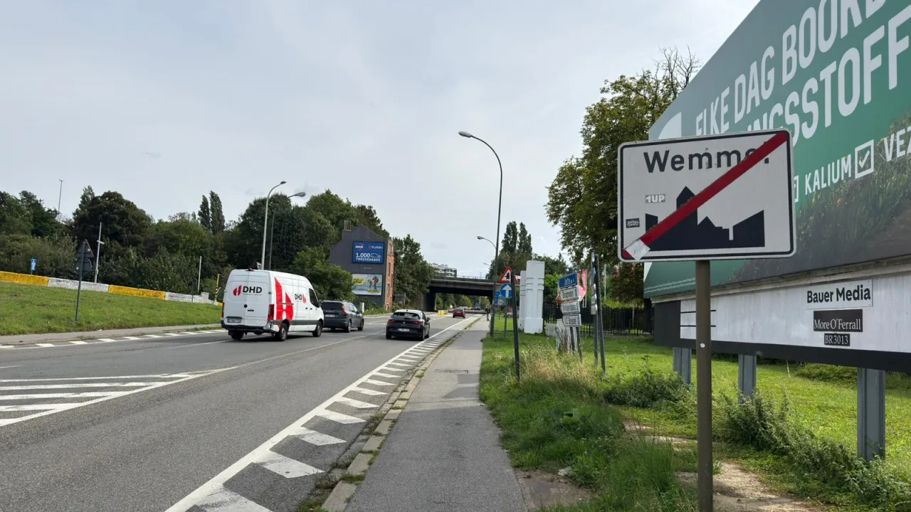 Signal de fin d'agglomération barré d'une diagonale rouge, au bord d'une route
