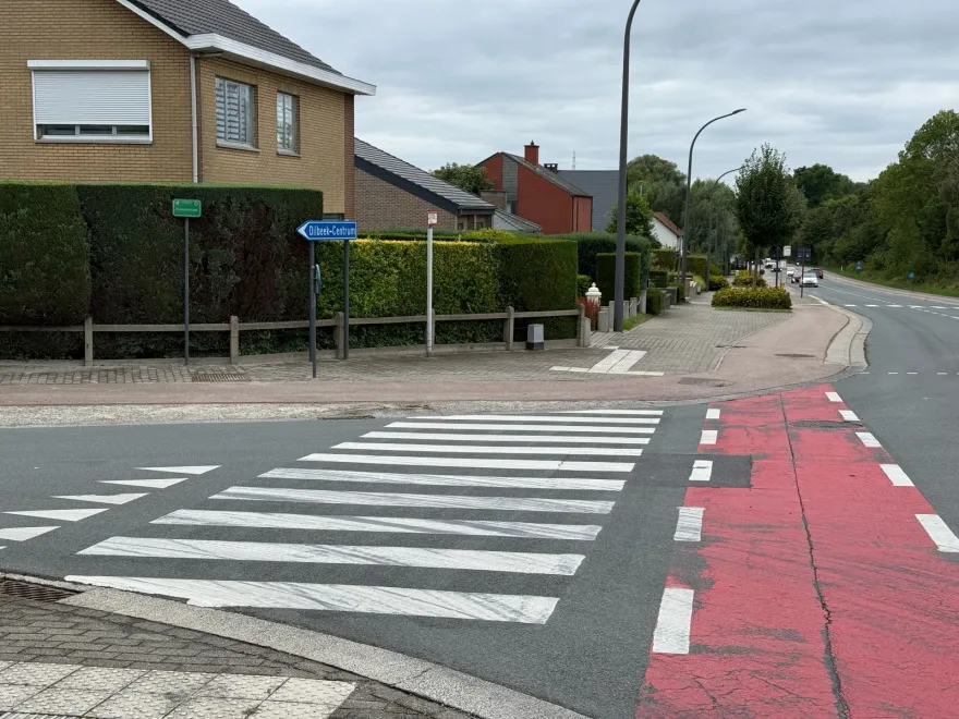 Passage pour piétons en bandes blanches et, juste à côté, un passage pour cyclistes en deux rangées de carrés sur une piste rouge