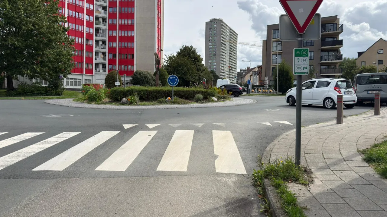 Entrée d'un rond-point avec un cédez-le-passage et des triangles blancs peints au sol