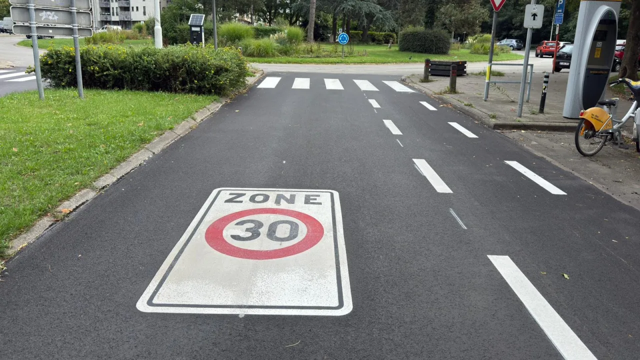 Marquage ZONE 30 peint en grand sur la chaussée, à l'entrée d'un quartier