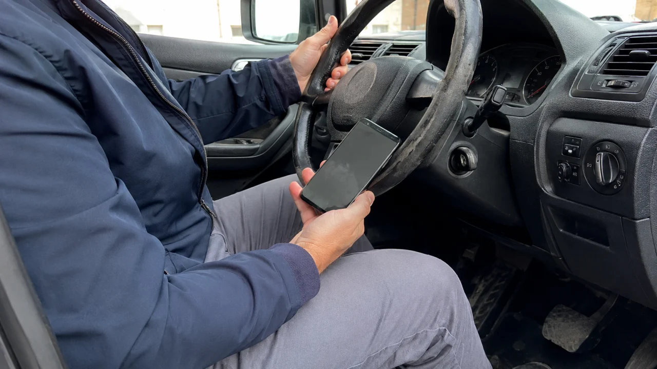 Ce conducteur est arrêté au feu rouge, moteur tournant. Peut-il prendre son téléphone en main ?