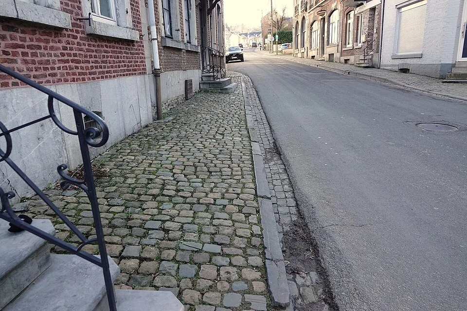Rue bordée de trottoirs des deux côtés, vue du conducteur