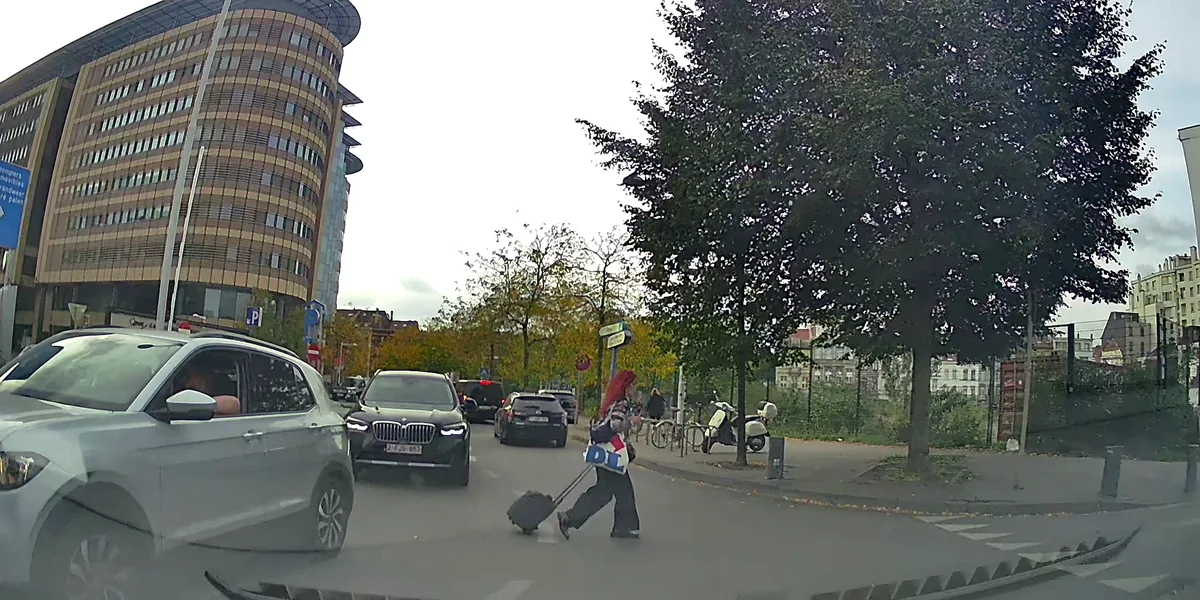 Test de perception des risques : une piétonne à valise traverse devant la voiture, zone à cliquer en vert